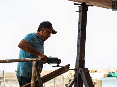 Incontriamo infatti il signore vicino allo scafo, mentre � alle prese con un�asse in legno che sta modellando con la levigatrice